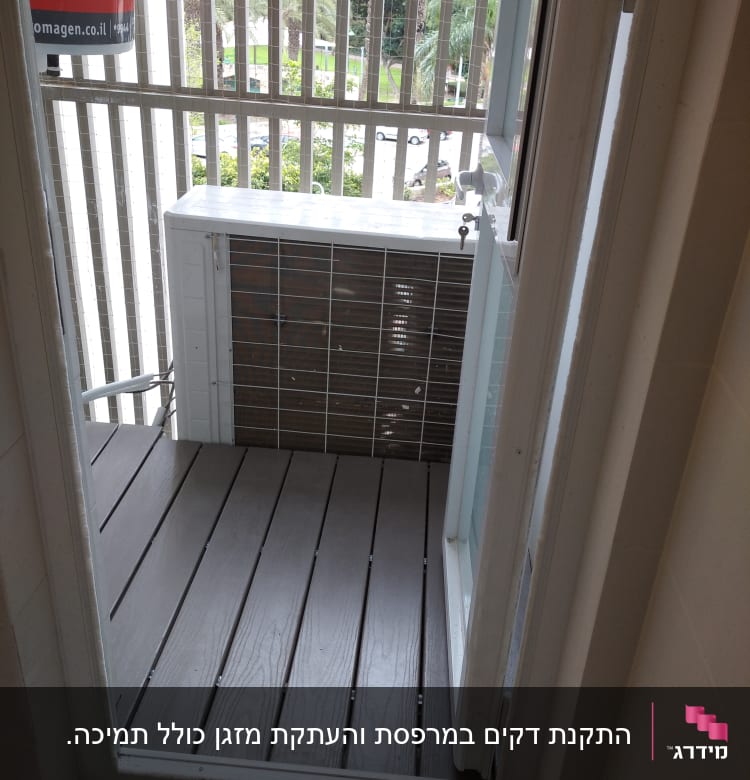 רצפת עץ במרפסת קטנה עם מעקה ברזל